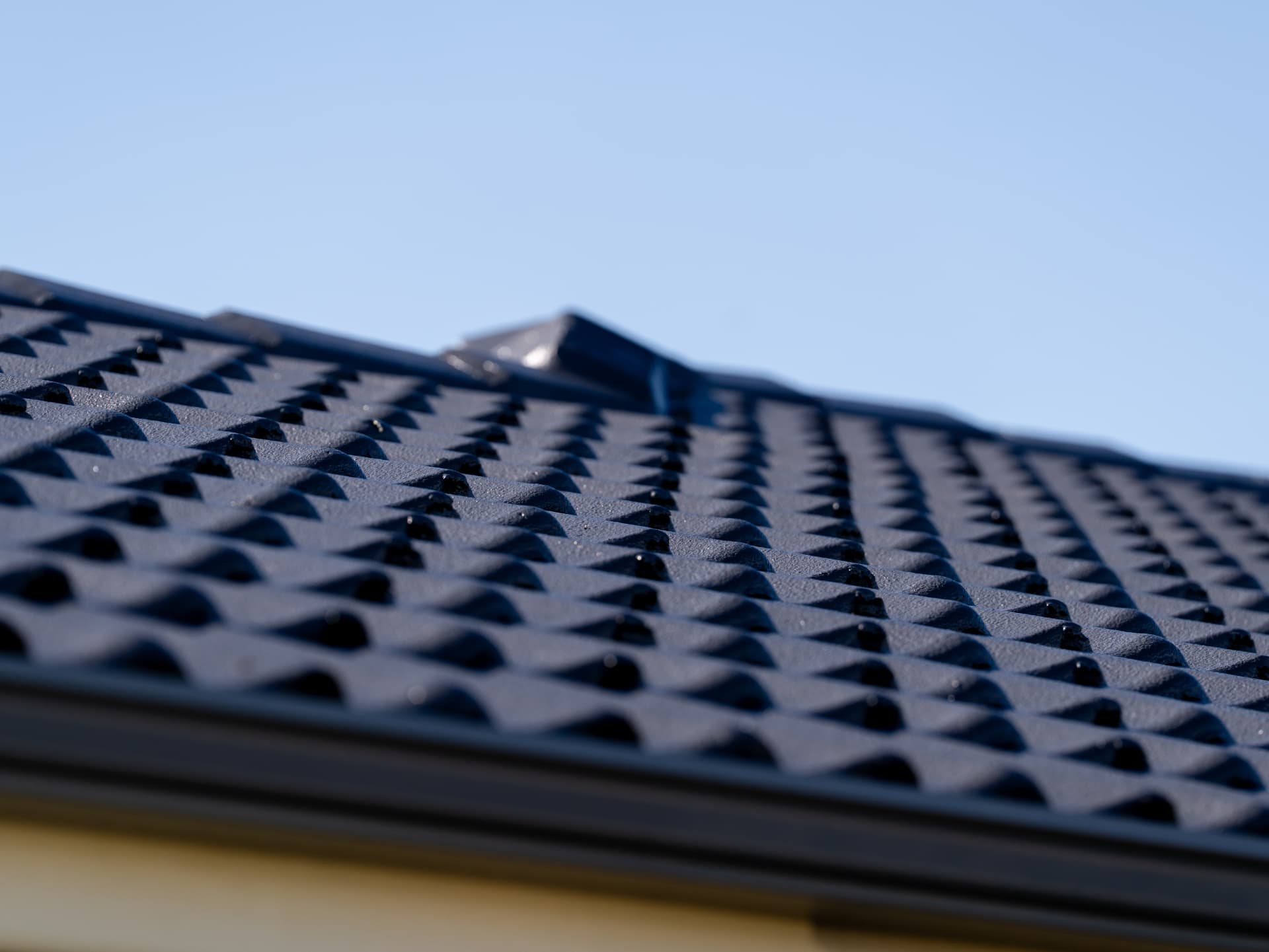Close-up of a freshly painted dark grey roof with clean lines and strong finish